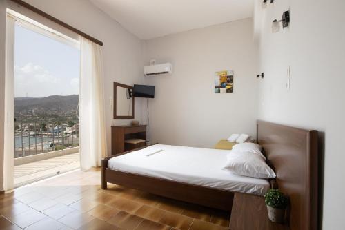 a bedroom with a bed and a large window at Seaside apartments in Alikí