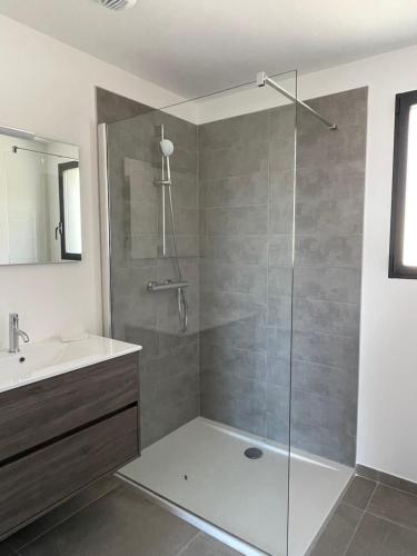 une salle de bain avec une douche avec une porte vitrée dans l'établissement Villa Marcaléone Corse du Sud, à Cirendinu