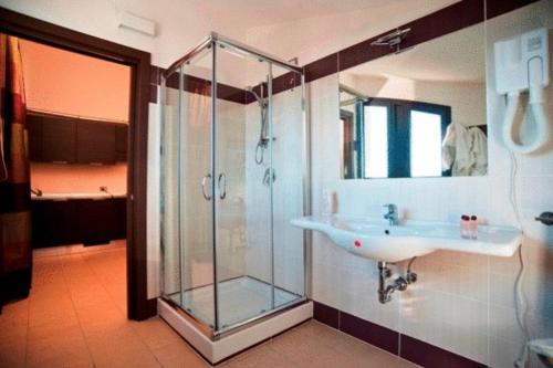 uma casa de banho com uma cabina de duche em vidro e um lavatório. em Hotel Massimino em Anguillara Sabazia