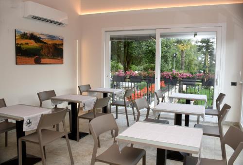 a room with tables and chairs and a window at Casale al Foino in Induno Olona