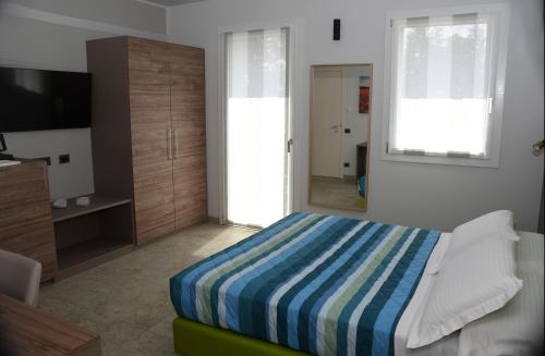 a bedroom with a bed and a flat screen tv at Casale al Foino in Induno Olona