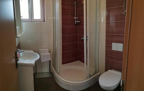 een badkamer met een douche, een toilet en een wastafel bij Apartman Kornu in Veli Lošinj