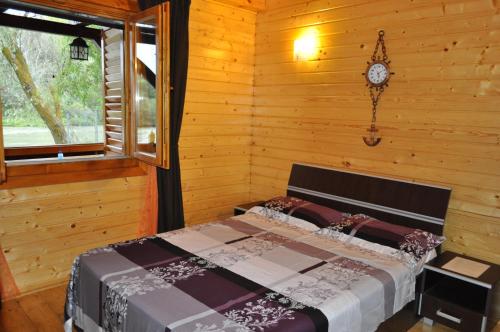 a bedroom with a bed and a clock on the wall at Casa Agapie in Uzlina