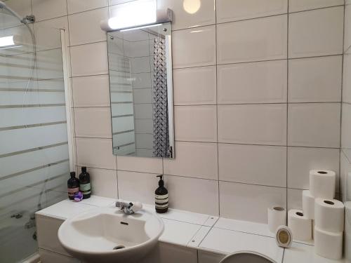 a white bathroom with a sink and a mirror at Luxury Private Mews Modern Apartment in the City in London