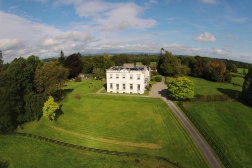 una vista aerea di una grande casa bianca in un campo di Lismacue House a Bansha