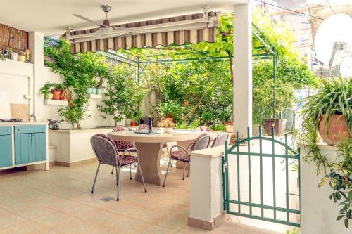 un patio con mesa, sillas y plantas en Comfort Apartment Dorin, en Makarska