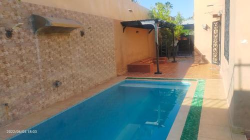 een zwembad in een huis met een tegelmuur bij Marrakech in Marrakesh