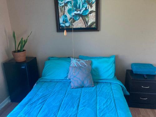 1 dormitorio con cama azul y edredón azul en Irises House - private room in home, en Kissimmee