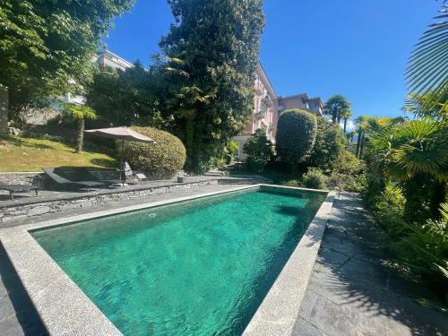 a swimming pool in front of a house at Villa Magnolia - High standing floor in Locarno