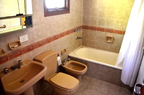 Un baño con inodoro, lavabo y bañera. en Vacances Dorado, en Pinamar