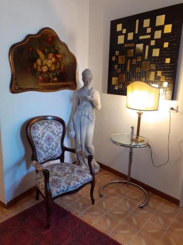una estatua de una mujer sentada en una silla junto a una lámpara en Foresteria, en Tuscania