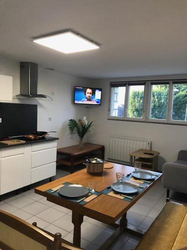 eine Küche mit einem Tisch und einem TV in einem Zimmer in der Unterkunft Villa BAKARA in La Roche-Posay