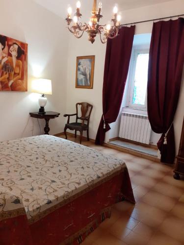 a bedroom with a bed and a window with red curtains at Foresteria in Tuscania