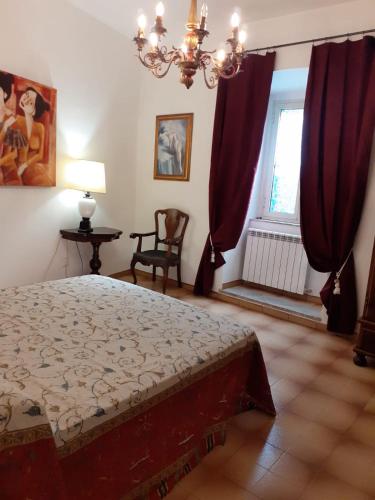 1 dormitorio con 1 cama y una ventana con cortinas rojas en Foresteria, en Tuscania
