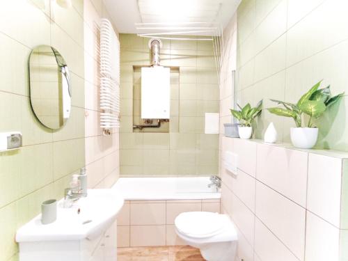 a white bathroom with a sink and a toilet at Apartament Kominek in Giżycko