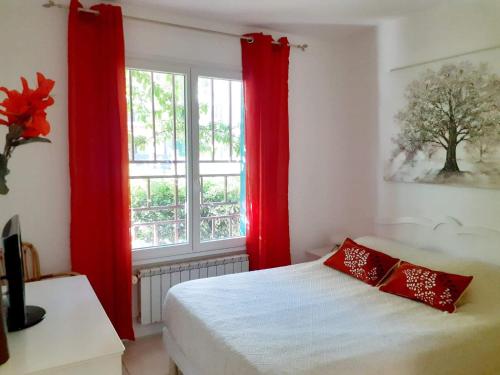 um quarto com cortinas vermelhas, uma cama e uma janela em Appart très cosy et confortable à Amélie les Bains em Amélie-les-Bains-Palalda