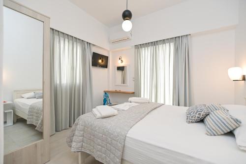a bedroom with two beds and a large mirror at AZUR in Naxos Chora