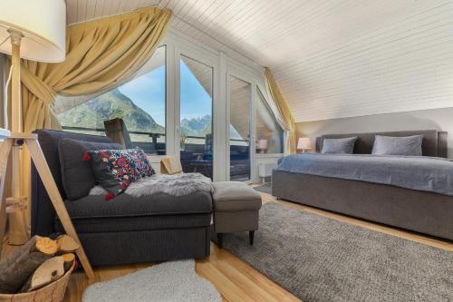a bedroom with a bed and a chair and a window at Rož'ca apartments with mountain view in Mojstrana