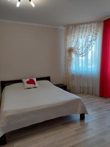 a bedroom with a large bed and a window at Квартира-студія центр Огієнка 2а in Lutsk