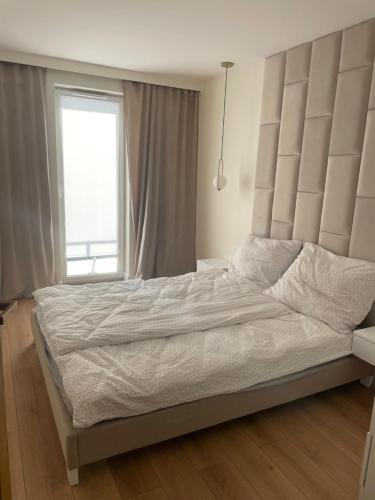 a bedroom with a large bed with a large window at Apartament Lili Słoneczne Tarasy in Dziwnówek