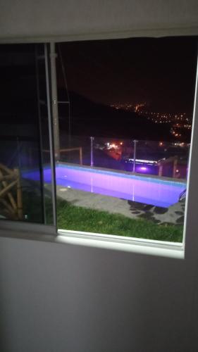 a window with a view of a soccer field at night at Tranquilidad y Sol in Cieneguilla