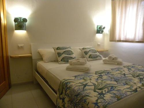 Un dormitorio con una cama con toallas. en Villa Carlotta la Maddalena, en La Maddalena