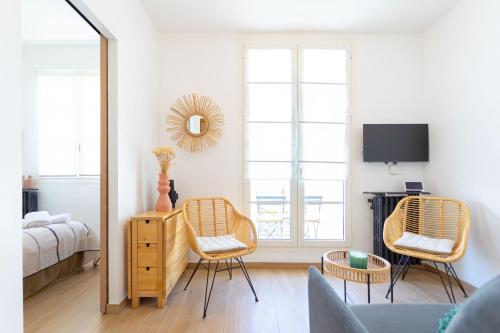 ein Schlafzimmer mit einem Spiegel, 2 Stühlen und einem Bett in der Unterkunft t2 Catalans in Marseille