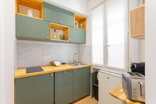 eine Küche mit blauen Schränken und einer Spüle in der Unterkunft t2 Catalans in Marseille