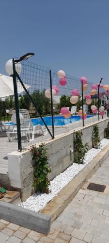 a fence with chairs and umbrellas and a swimming pool at Debel house in Marina di Ragusa
