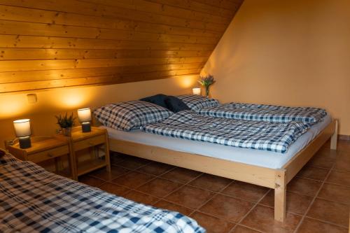 2 camas en una habitación con 2 lámparas en las mesas en Chalupa Bišík en Teplice nad Metují