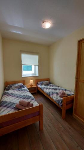a bedroom with two beds and a window at Farfalle di Valle in Bale
