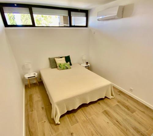 a small bedroom with a bed and a window at Vilamoura - Apartamento Praia e Golf PL I in Vilamoura