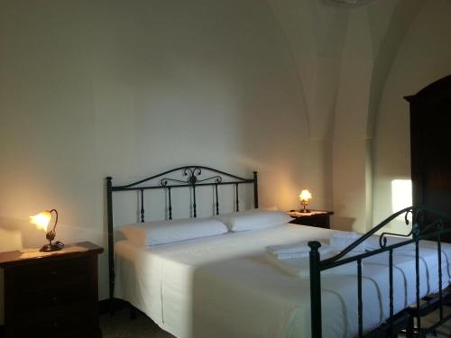 ein Schlafzimmer mit einem Bett und zwei Lampen an Tischen in der Unterkunft Mercanti in Manduria