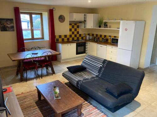 un salon avec un canapé et une table et une cuisine dans l'établissement La Mare aux oiseaux 1608, à Sassenage