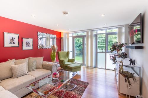 a living room with a couch and a red wall at Luxury at The Brunswick - Free Parking-4 bedrooms in Brighton & Hove