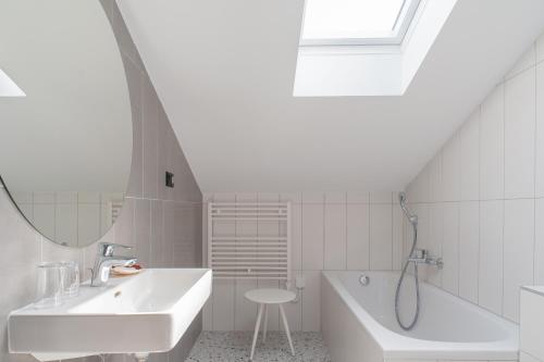 a white bathroom with a sink and a tub at Boutique hotel Lili in Rovinj