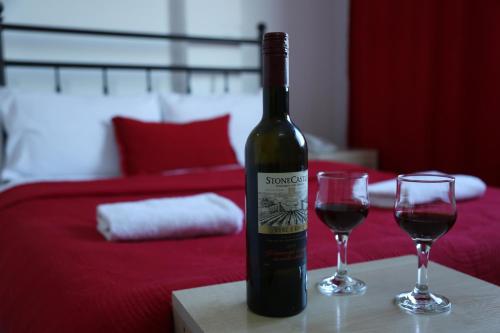 Hotel Sara & SPA في بريشتيني: زجاجة من النبيذ وكأسين على الطاولة