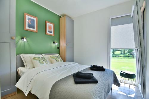 ein Schlafzimmer mit einem Bett und einer grünen Wand in der Unterkunft Cisza & Spokój in Człopa