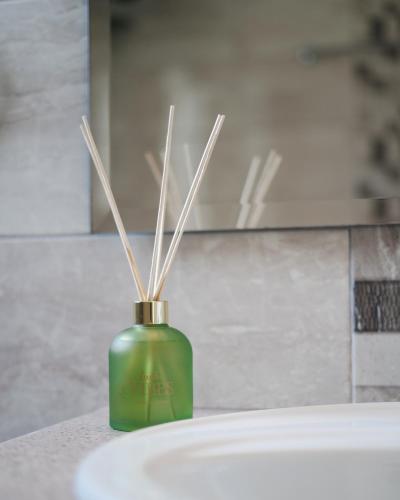 a green vase with sticks in it on a counter at Residence Poseidon in Spartia