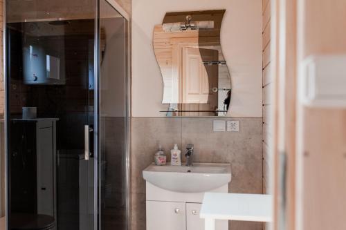 a small bathroom with a sink and a shower at Tęcza Mazur in Kątno