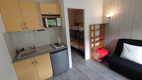 a small kitchen with a sink and a couch in a room at Portillo in Puy-Saint-Vincent