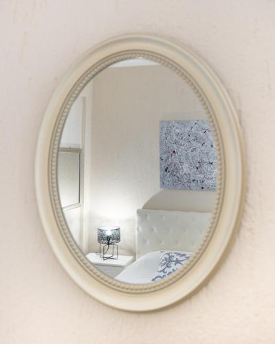 a mirror hanging on a wall with a bedroom at Residence Poseidon in Spartia