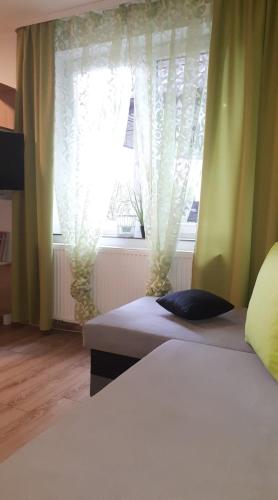 a bedroom with two beds and a window at Cienisty Zakątek in Augustów