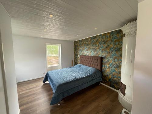 um quarto com uma cama com um edredão azul em Hälla 1 nära jönåkers golfbana em Jönåker