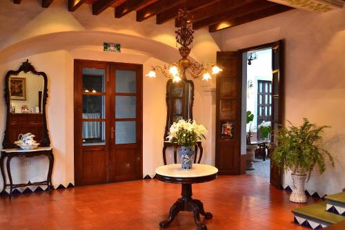 a room with a table with a vase of flowers on it at Meson del Alferez Coatepec in Coatepec