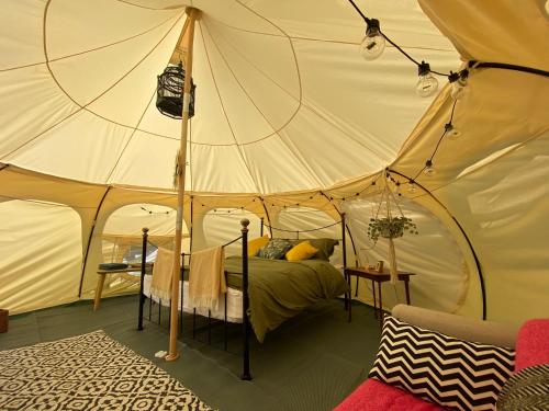 a bedroom with a bed in a tent at Secret Garden Glamping in Lymington
