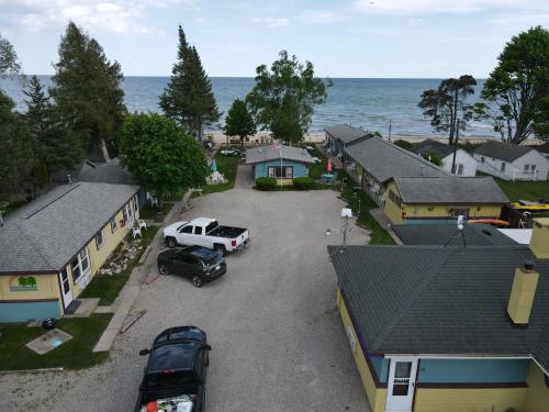 una vista aérea de una pequeña ciudad con coches aparcados en un aparcamiento en Paradise Beach resort, en Tawas City