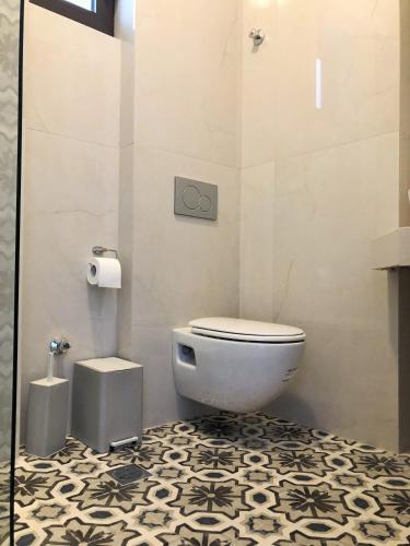 a bathroom with a toilet and a black and white floor at House Marianthi Anthoula in Sarti