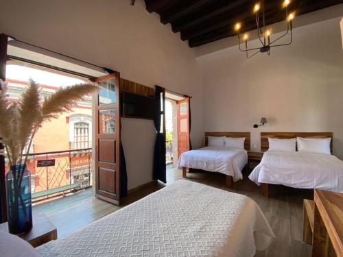 - une chambre avec 2 lits et une grande fenêtre dans l'établissement Palacio de las Rosas, à Durango