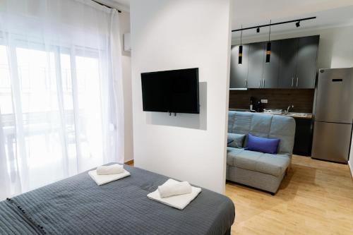 a bedroom with a bed and a tv on a wall at Stamatina's Luxury Apartment (Little Suite) in Alexandroupoli